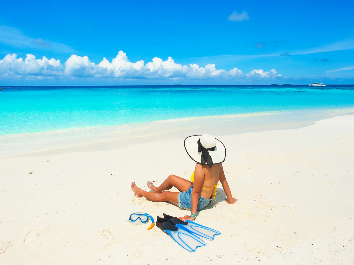 A guest on the sand beside her snorkel fins